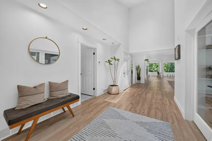 Entryway featuring vaulted ceilings, recessed lighting, wood-finish flooring, and crisp white walls
