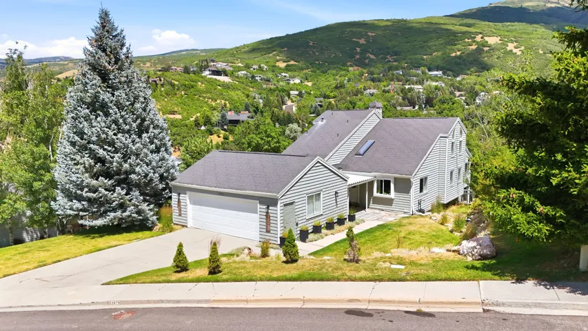 Multi-level residence featuring gray siding and a dark shingle roof