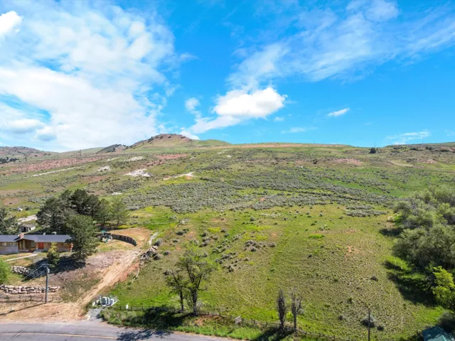 Expansive green hillside property with distant mountain terrain