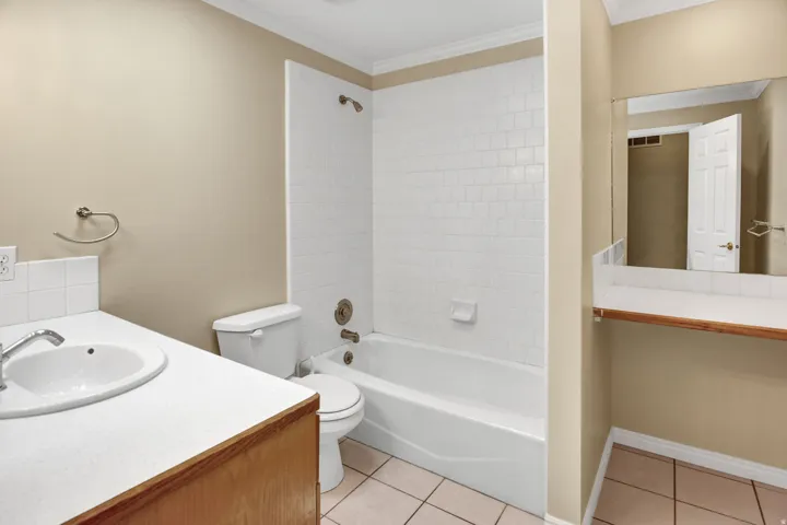 Bathroom featuring a white bathtub, ceramic tile shower surround, and a vanity with an integrated sink, 2nd make up vanity