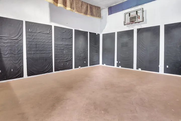 Spacious indoor recreational area featuring a basketball hoop and a large open floor. 24X20 under garage. with separate access