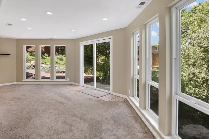 View 2 with lots of view windows and sliding glass door to backyard deck. Recessed lighting illuminates this carpeted room