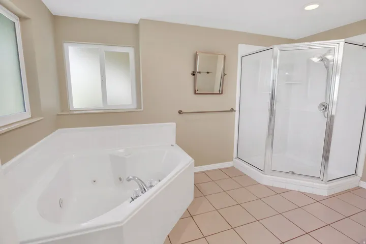 Corner jetted tub with separate shower. polished chrome fixtures and frosted window