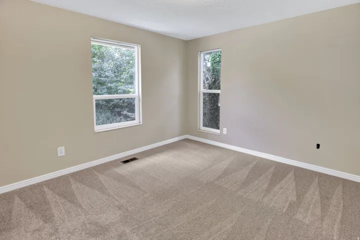 Neutral-toned walls complement the light tan carpeting