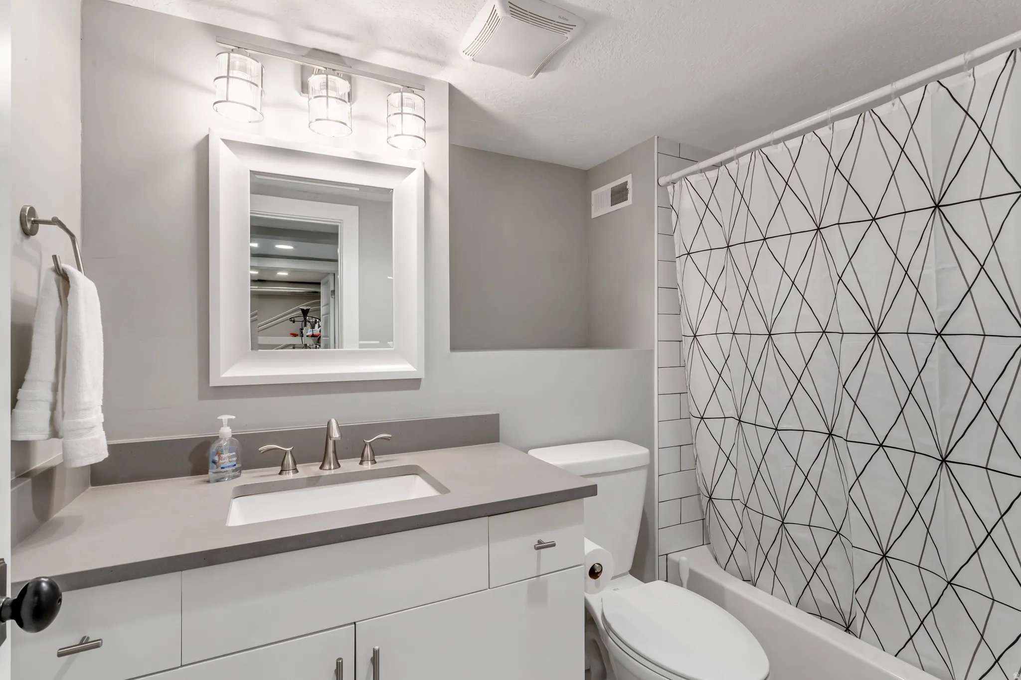 Modern bathroom featuring a contemporary vanity with a rectangular undermount sink, brushed nickel faucet, and a light gray countertop