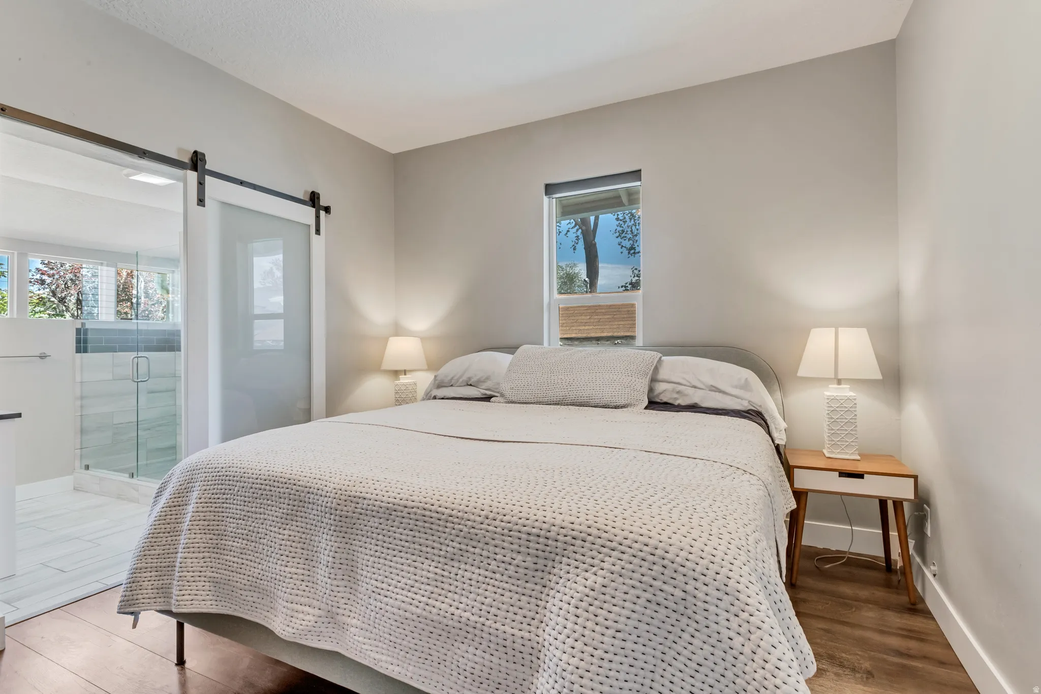 Bedroom featuring wood-finish flooring and a single window