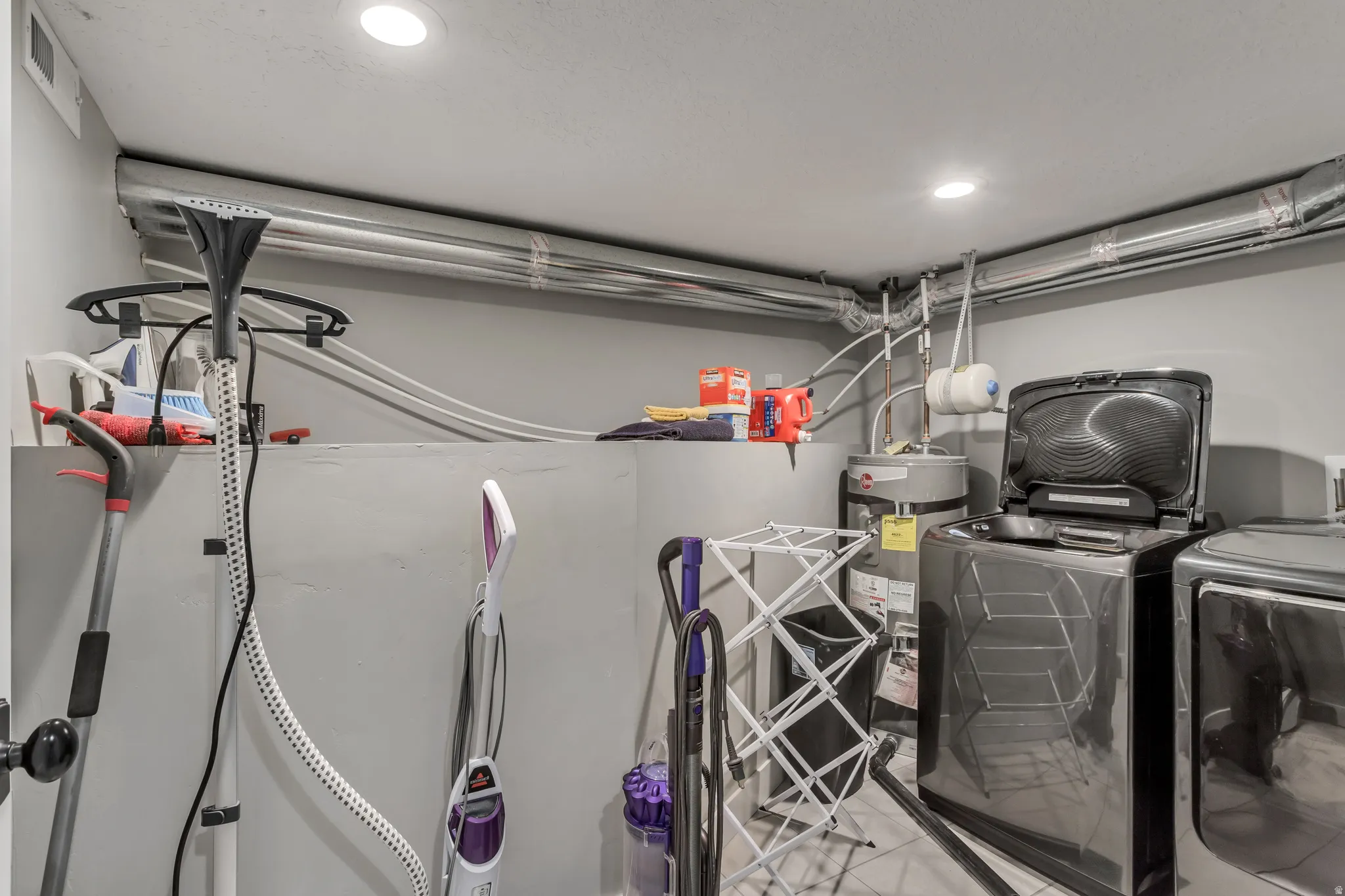 Dedicated utility area featuring a water heater, visible ductwork, and recessed ceiling lighting