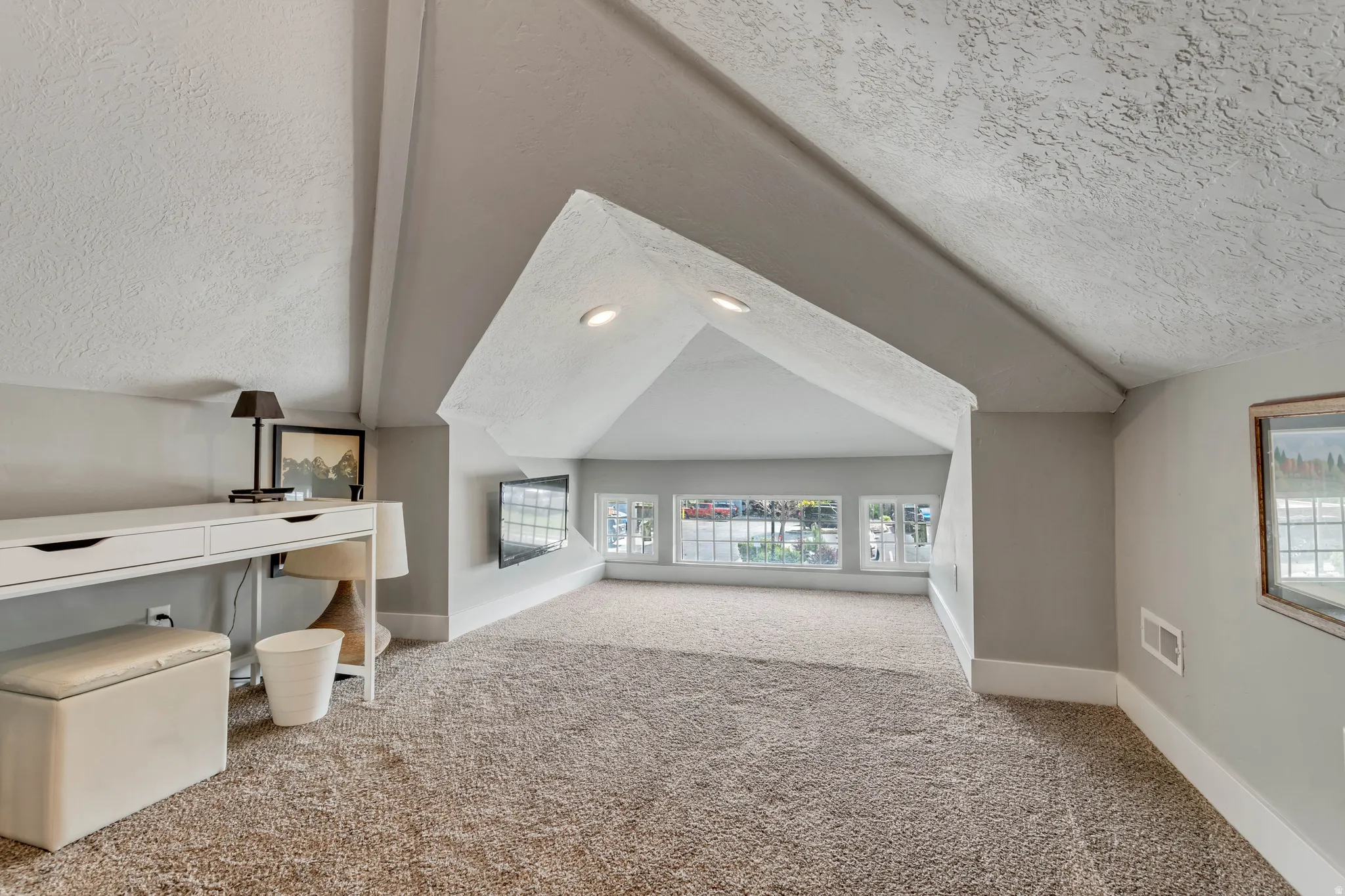 Carpeted room with recessed lighting and sloped ceilings