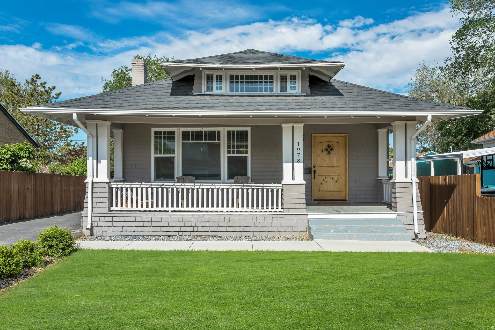 Craftsman-style home featuring a covered front porch with white balusters and columns
