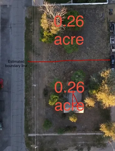 Aerial view of a 0.26-acre parcel featuring mature trees, a detached structure, and direct street frontage