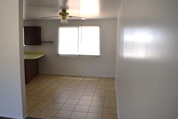 Dining area featuring tile flooring, a window with horizontal blinds, and a ceiling fan