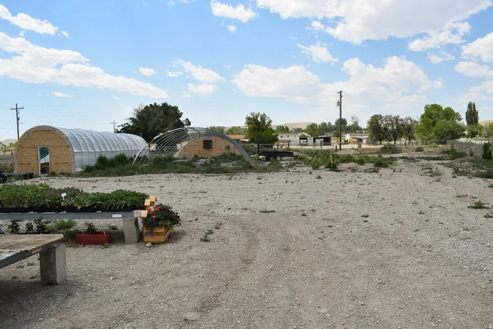 Expansive gravel lot featuring two hoop-style greenhouses