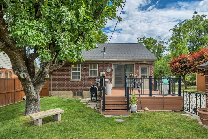 Brick exterior featuring a wood-look composite deck with black railings and steps
