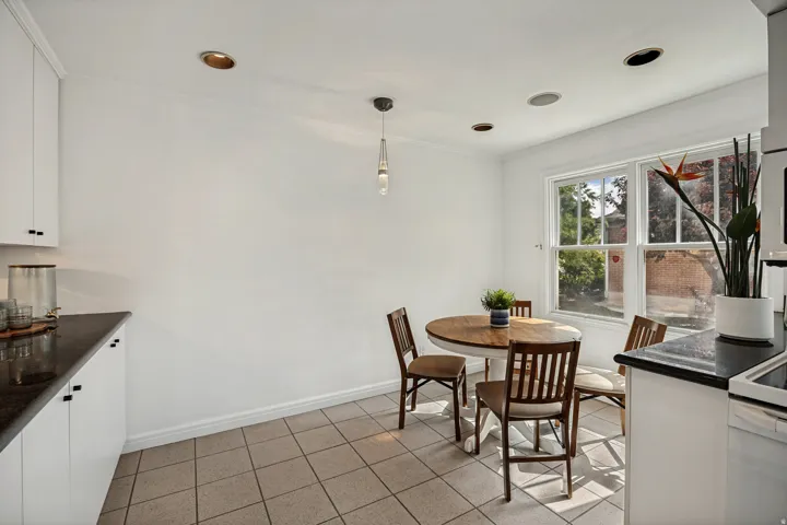 Recessed ceiling lighting complements a contemporary pendant fixture over a tiled floor