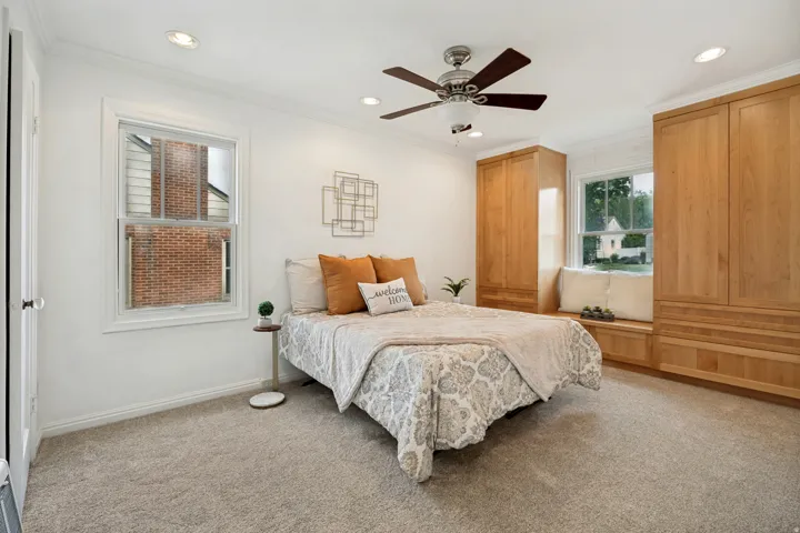 Carpeted room featuring recessed lighting, a ceiling fan, a built-in window seat, and integrated wood-finish cabinetry