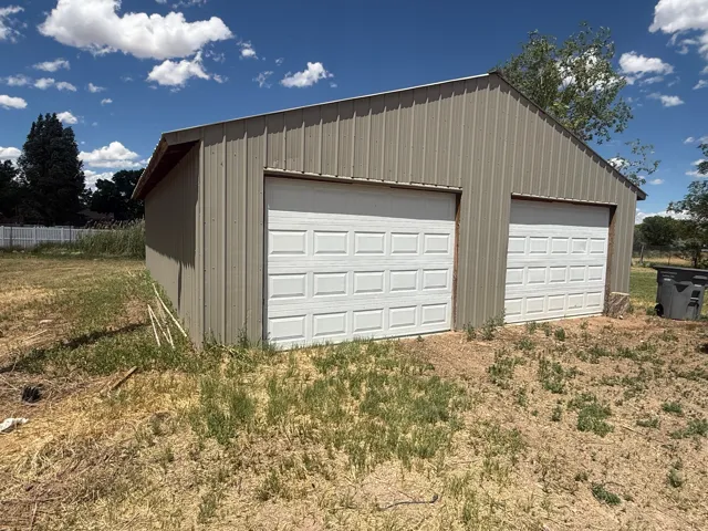 Detached structure featuring corrugated metal siding and a gable roofline