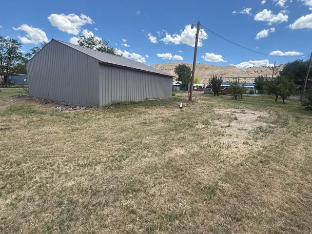Corrugated metal outbuilding featuring a sloped roof