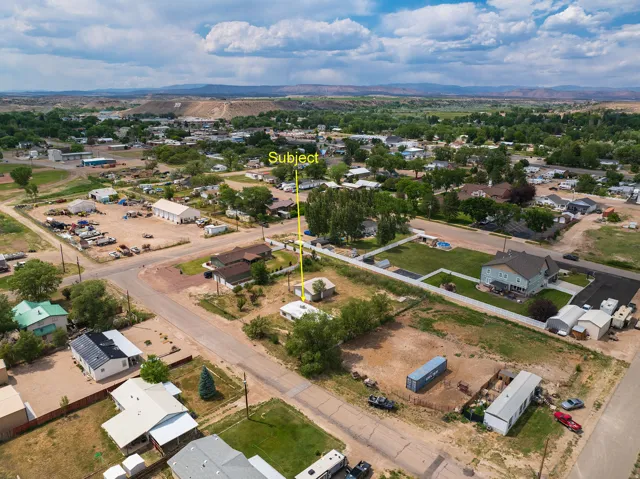 Aerial perspective showcasing the subject property situated within a residential area, surrounded by diverse architectural styles and mature trees