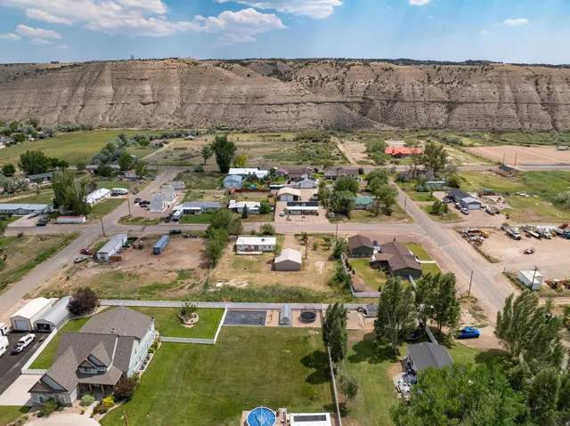Expansive aerial view showcasing properties with a prominent natural rock formation backdrop
