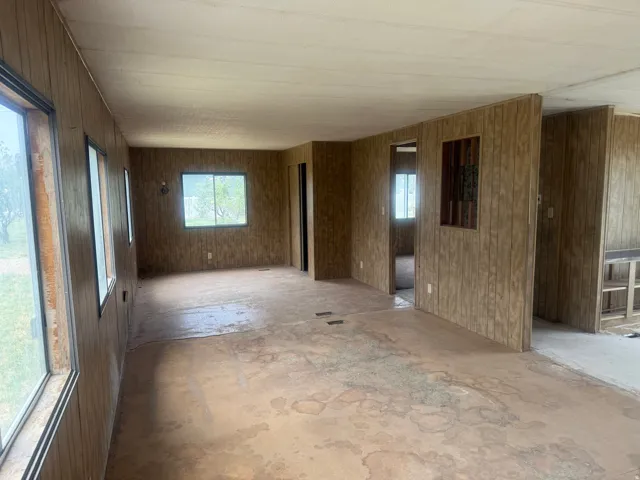 Spacious interior featuring wood-panel walls, multiple windows, and a built-in wall niche
