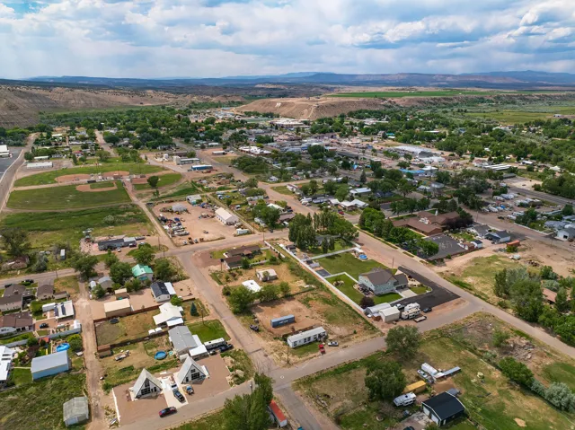 Expansive aerial perspective showcasing a residential district framed by distant hills and green fields