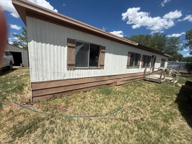 White corrugated siding exterior with brown trim and matching accent shutters