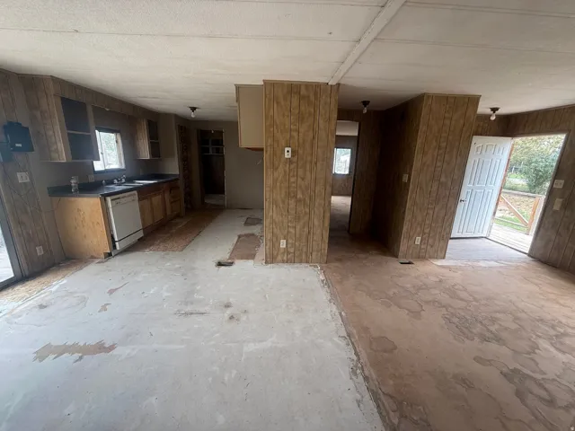 Kitchen area featuring wood-panel walls, base cabinets, and upper cabinetry