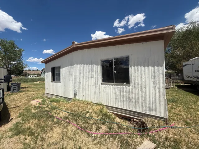 White corrugated siding exterior with brown eaves