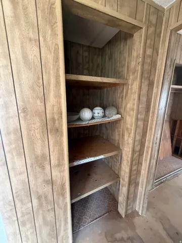 Built-in shelving unit with wood-finish paneling, featuring multiple storage shelves