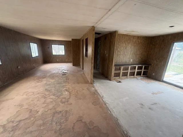 Expansive interior space featuring wood-paneled walls and multiple windows