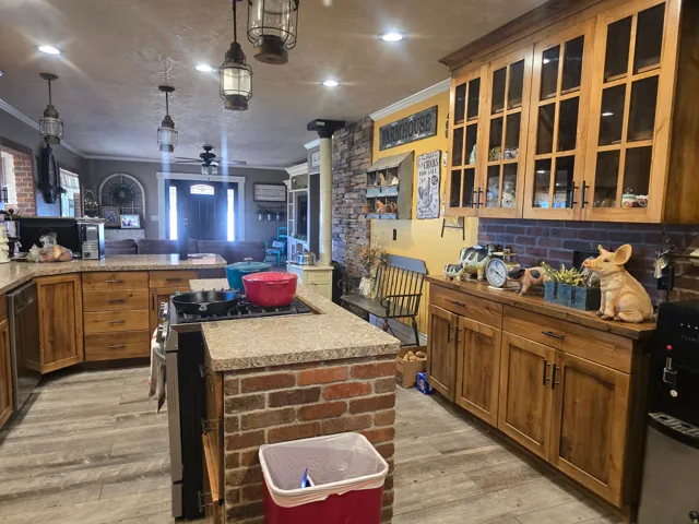 Kitchen featuring a brick island with integrated cooktop, wood-finish flooring, recessed lighting, and natural wood cabinetry