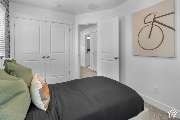 Bedroom with white trim, two-panel interior doors, and carpeted flooring