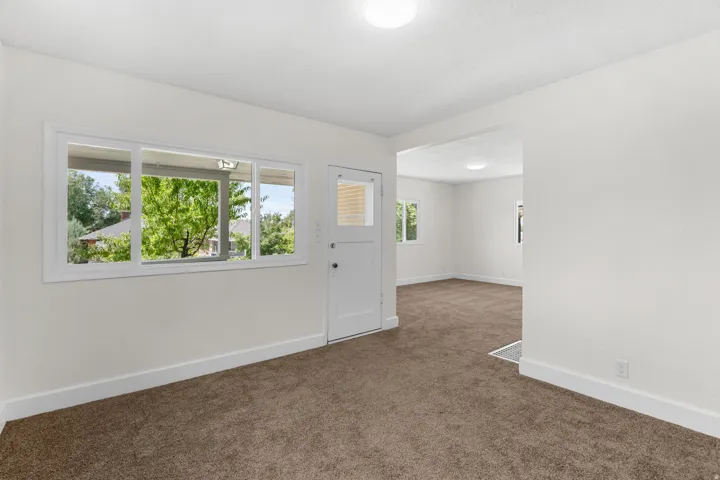 Interior room with neutral carpet, white walls, and white baseboards