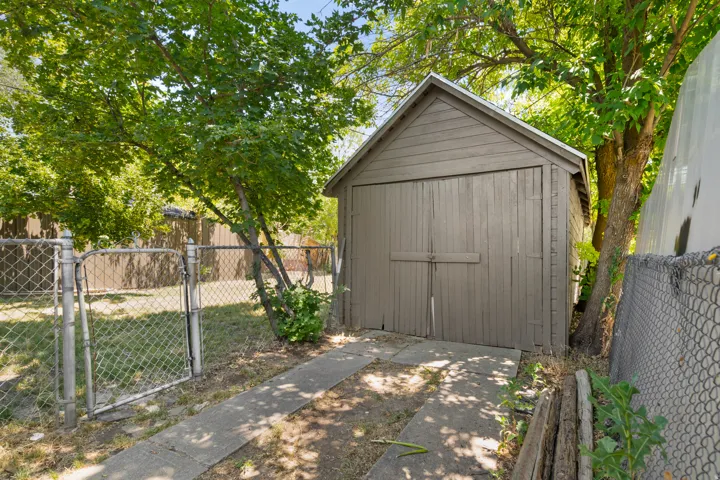 Detached garage structure with double wooden doors and a pitched roof