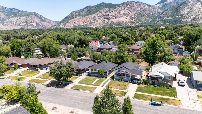 Residential neighborhood featuring established homes and mature trees against a mountain backdrop