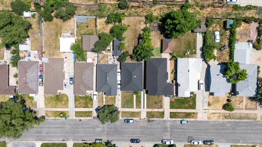 Aerial view showcasing multiple residential properties with varied roof styles and landscaping