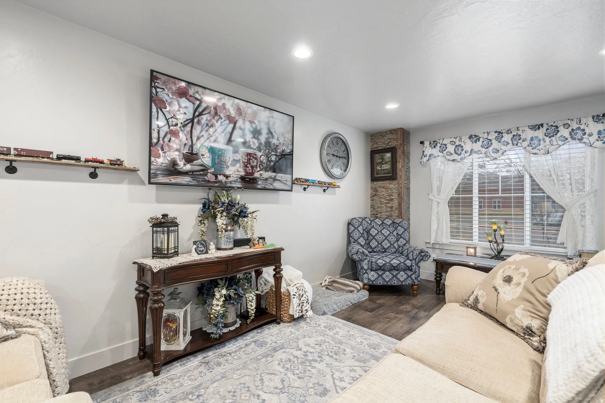 Living area featuring recessed lighting, a window with horizontal blinds, wood-finish flooring, and a stone accent wall