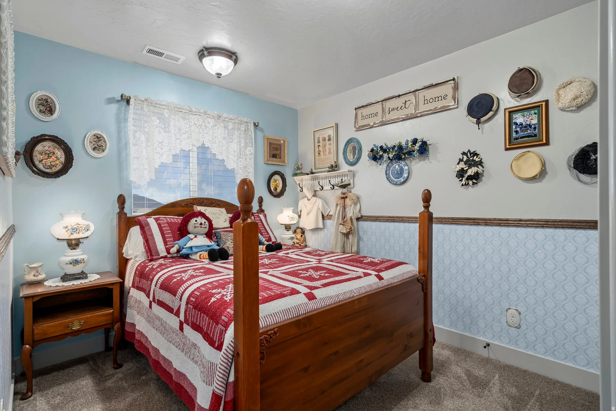 Carpeted room featuring a window with blinds and lace curtains, a ceiling-mounted light fixture, and two-tone wall treatment with a chair rail