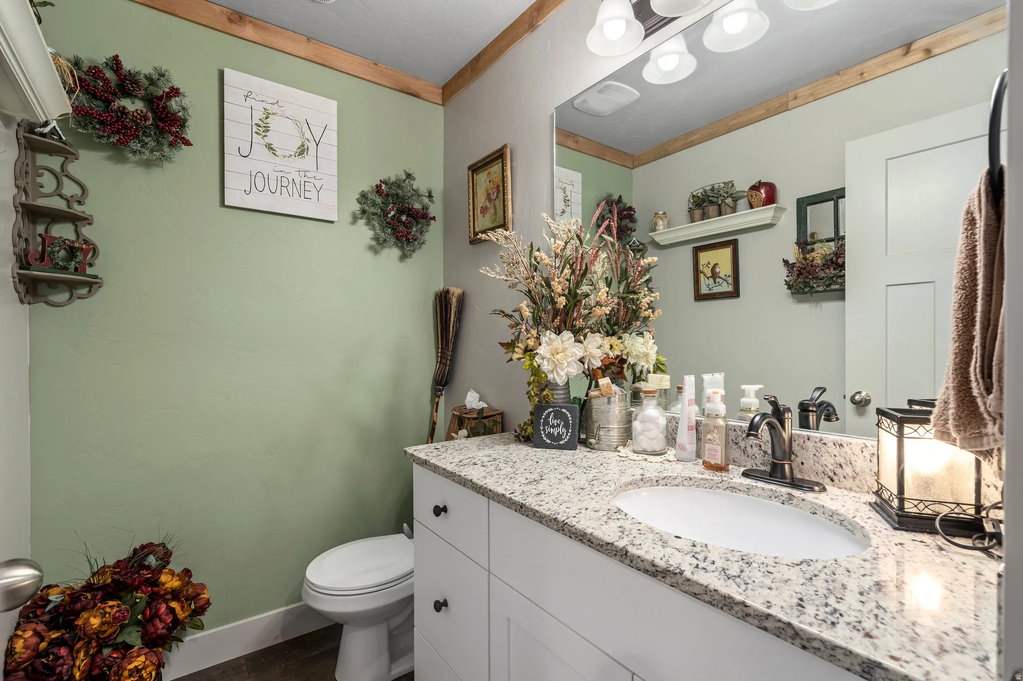 Bathroom featuring a vanity with a granite-style countertop, undermount sink, and dark-finish faucet