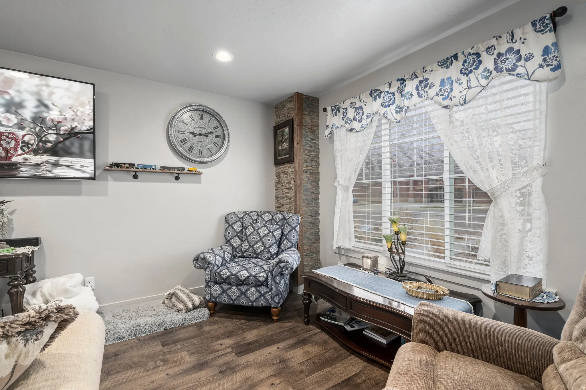 Living space featuring wood-finish flooring, recessed lighting, and a window with horizontal blinds