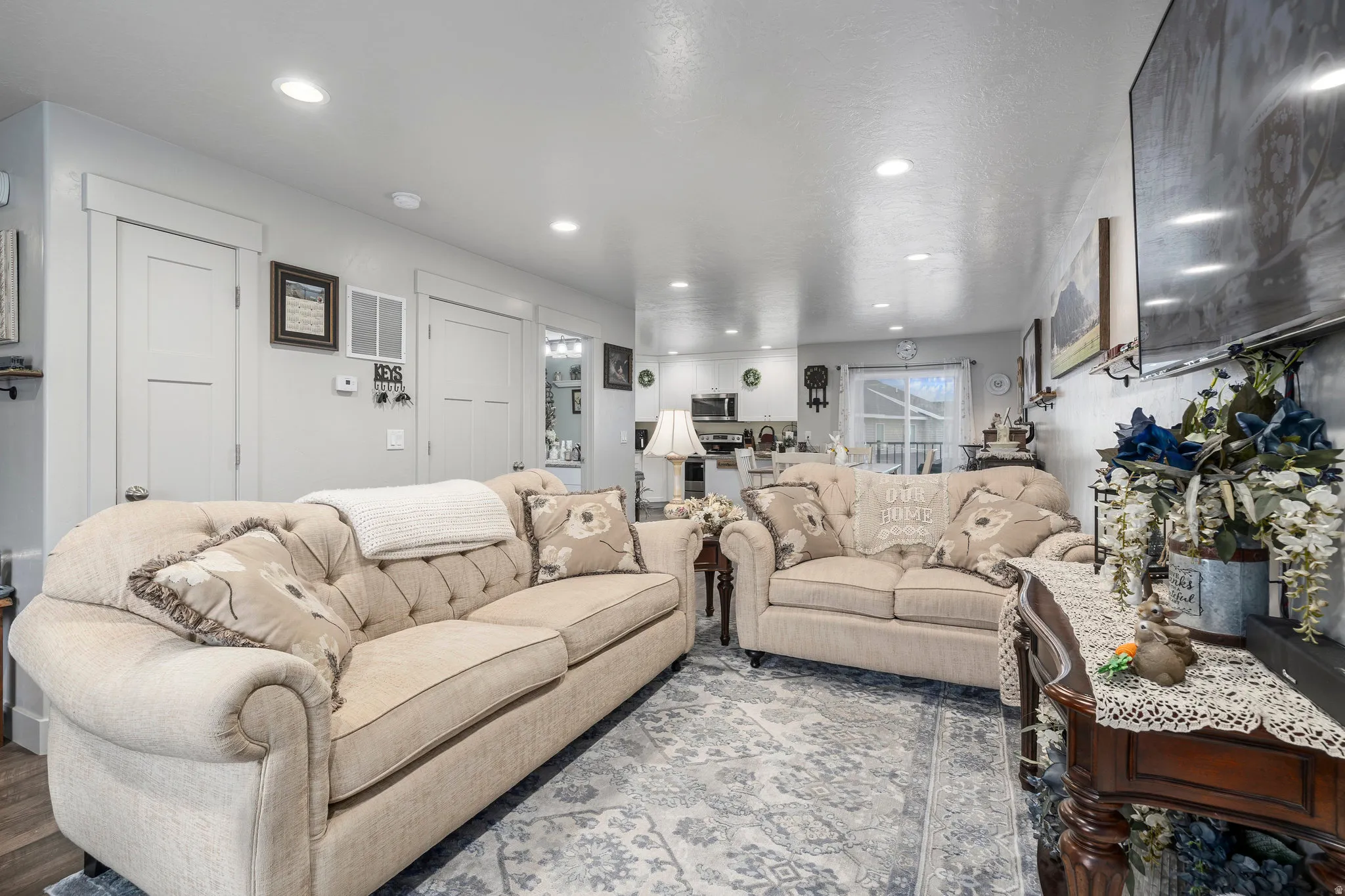 Open-concept living space featuring recessed lighting, light gray wall tones, and a patterned area rug