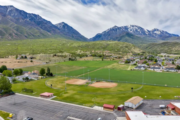 Expansive athletic fields featuring two baseball diamonds and green space, surrounded by residential areas and agricultural land