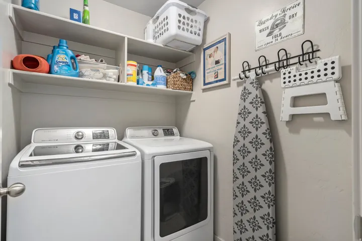 Dedicated laundry area featuring a white top-load washing machine and front-load dryer