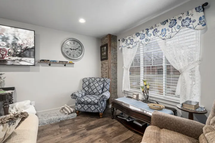 Living space featuring wood-finish flooring, recessed lighting, and a window with horizontal blinds