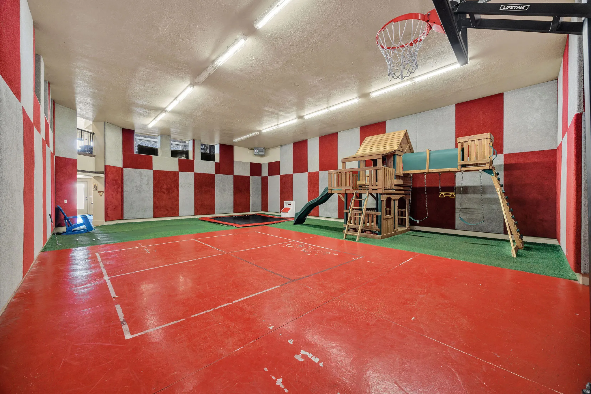 Indoor recreation space featuring a red-and-white checkered wall design and fluorescent ceiling lighting