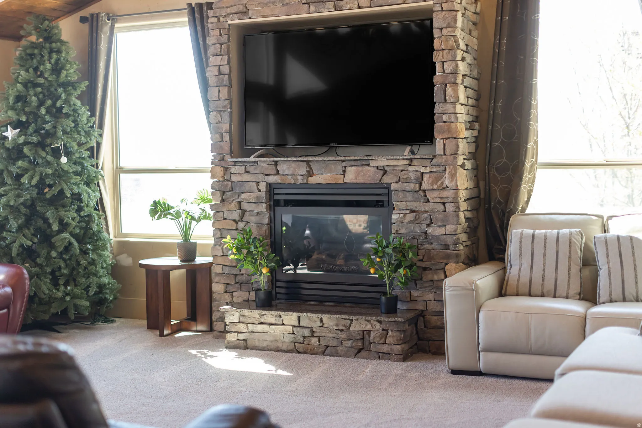Stone-clad fireplace with hearth, featuring an integrated media niche and sleek black insert