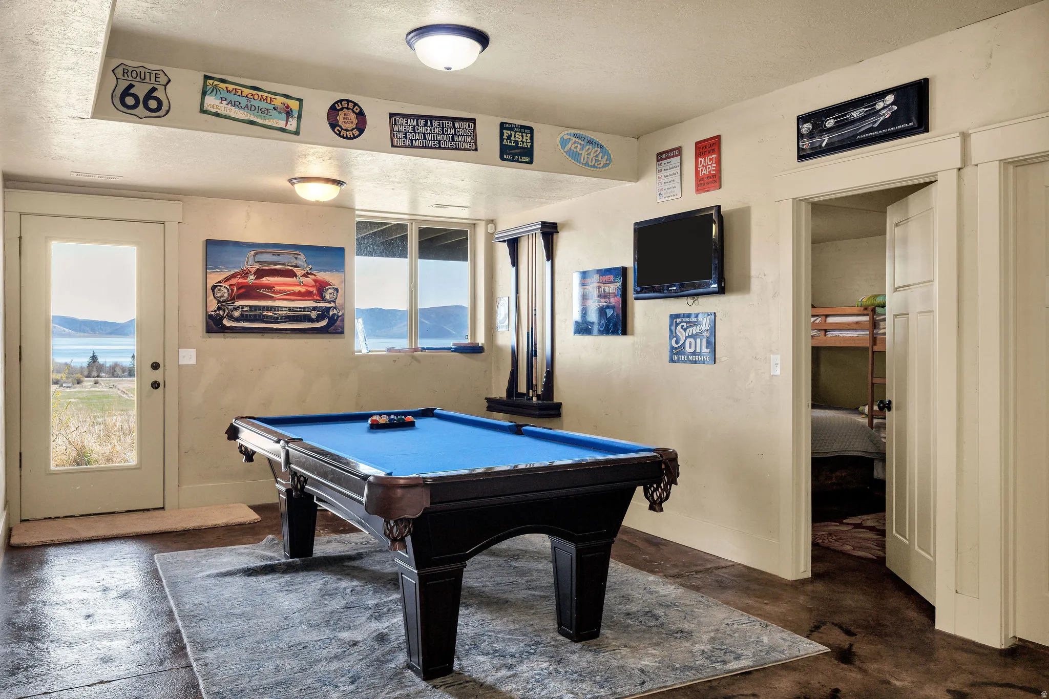 Recreational space featuring a full-size billiard table, concrete flooring, and an exterior door with integrated window