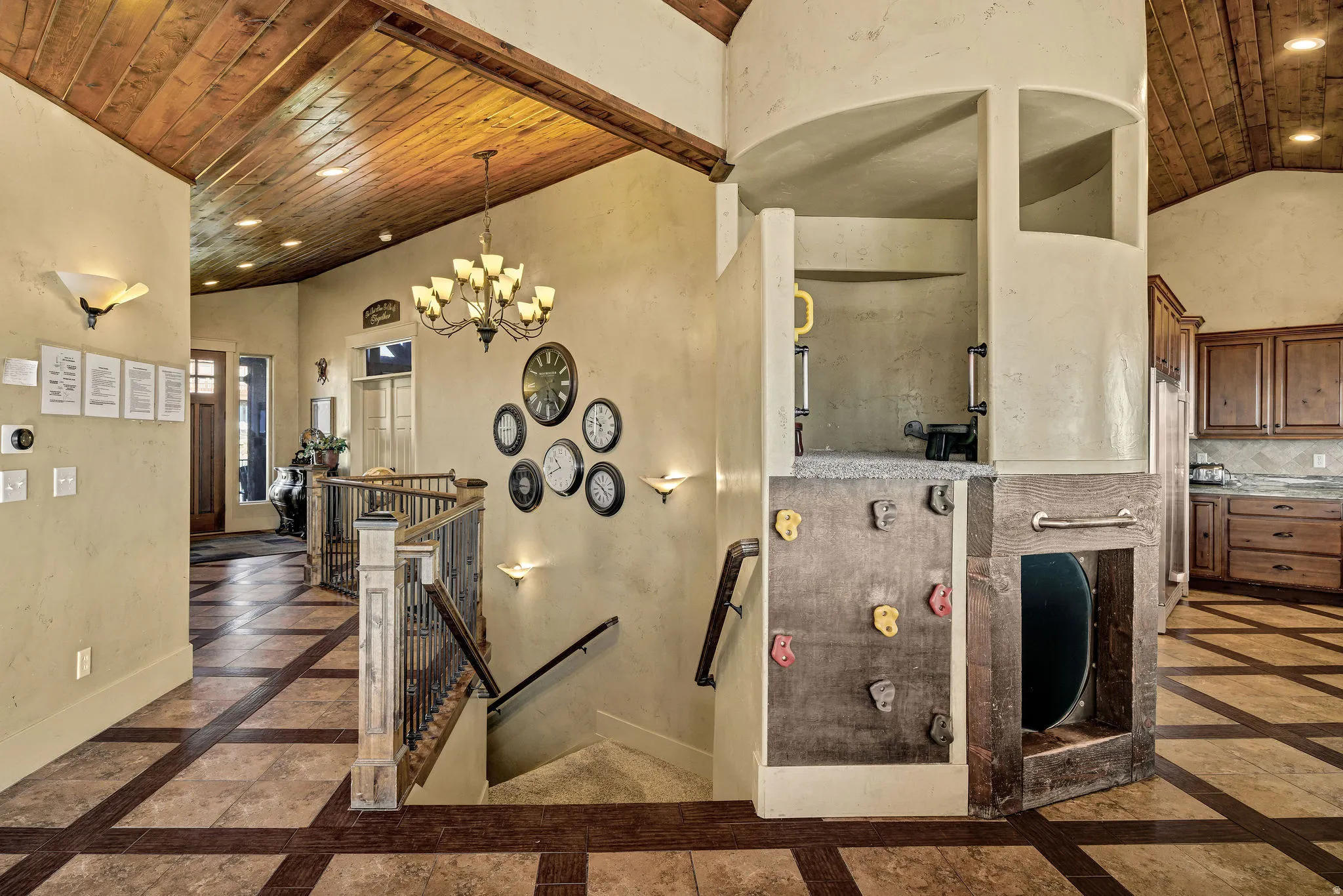 Vaulted wood-paneled ceiling with recessed lighting and a classic chandelier