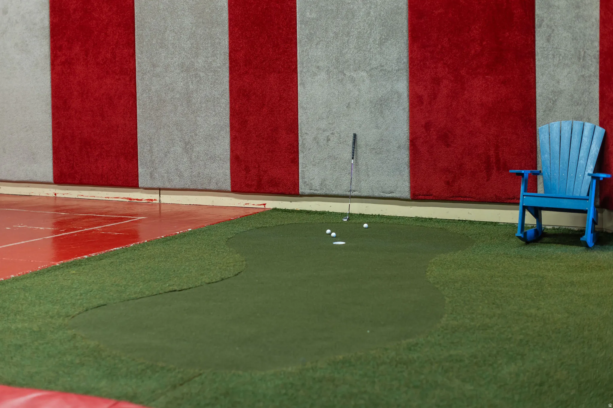 Indoor putting green with surrounding artificial turf