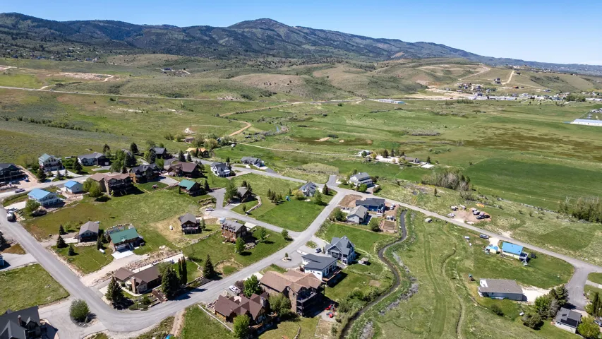 Expansive landscape featuring scattered residential properties, paved roadways, and a natural water feature